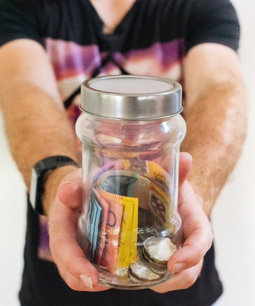 man holding clear glass jar